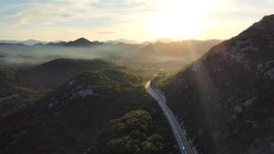 Amazing sunset aerial top drone view of high-speed road between the picturesque mountains. Top down view of picturesque mountain serpentine stretching into the distance. Beautiful nature of Montenegro