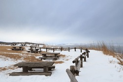 Picnic tables on snowy clifftop in winter