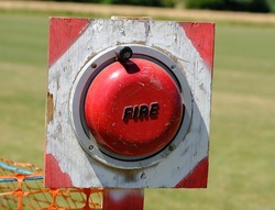 Hand operated fire alarm bell on outdoor camping and caravan site.