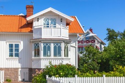 Idyllic white wooden house with garden in summer