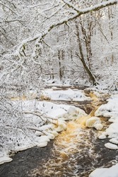 Running water in a river by a beautiful wintry landscape