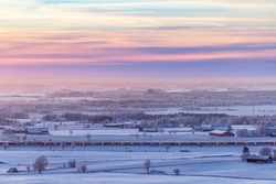 Wintry countryside view at dusk with a train