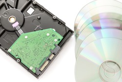 Hard disk drive (HDD) with circuit board and dvd discs on white background