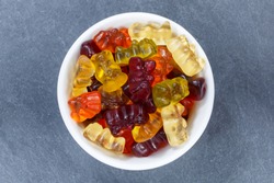Gummy bears sweets gummybears from above bowl on a slate