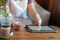 women hold card and use tablet on wood table,Online shopping,hands holding credit card and using laptop,personal loans, 