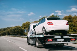 Car Service Transportation Concept. Tow Truck Transporting Car On Motorway Freeway Highway. Help On Road Transports Wrecker Broken Car. Transportation Faults And Emergency Cars.