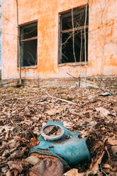 Gasmask Near Abandoned Ruined Old Village School Building In Chernobyl Resettlement Zone. Belarus. Chornobyl Catastrophe Disasters. Dilapidated House In Belarusian Village. Whole Villages Must Be