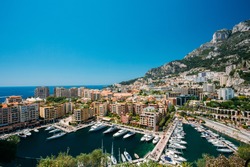 Yachts moored near city Pier, Jetty In Sunny Summer Day. Monaco, Monte Carlo architecture.