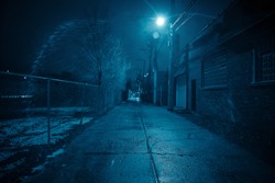 Dark and eerie urban city alley at night in the winter