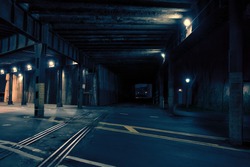 Dark urban downtown city train tunnel at night.