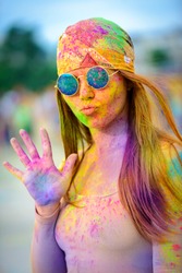 Young cheerful woman at Holi paint party