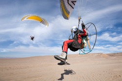 Foot launch paramotor taking off or take off or landing in desert. Powered paraglider (