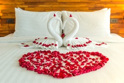 Beautiful hotel for honeymoon sweet.Swan couple put on honeymoon bed look like heart shape with rose petals for honeymoon lover.The staff hotel put yellow lighting in the room make romantic feeling.

