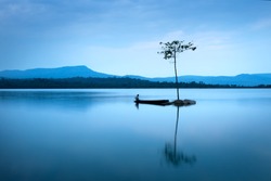 Natural landscape in blue. A boat floating in smooth water at tranquil lake .Many traveller come for relaxing after hard working. This a beautiful gift from the nature  