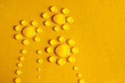 Water drops with the shape of three flowers in yellow background