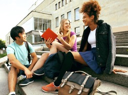 cute group of teenages at the building of university with books 