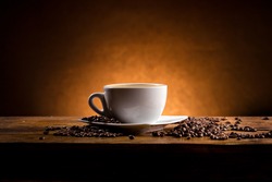 cup of coffee on a wooden table on dark background