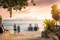 Happy couple on the tropical beach of Phi Phi island at sunset in Southern Thailand. Travel magazine concept.