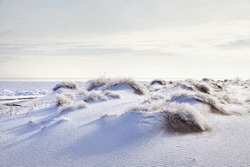 Surreal landscape of Ripple wave of sand dune covered with snow in the desert in Kazakhstan at winter