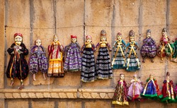 Colorful Rajasthan puppets hanging in the shop of Jaisalmer City Palace, India    