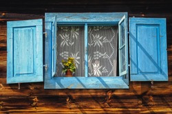 Blue window shutter of wooden cottage in Poland