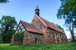 Old bricks and stones gothic church from XIV century in small village Chlebowo, Poland