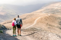 Fit, middle age couple on the trail to the highest peak of Fuerteventura, Spain