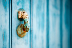 Weathered knocker on blue wooden door in Algarve, Portugal