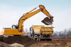 Building Machines: Digger loading trucks with soil