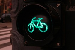 Green colored traffic light with bike sign for cyclists close up