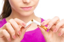 Young woman is breaking a cigarette, quit smoking concept, isolated over white