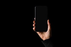 Person holding in hand smartphone, isolated on black background