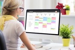 Woman using calendar app on computer in office