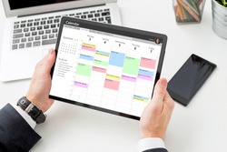 Businessman using calendar app on tablet computer