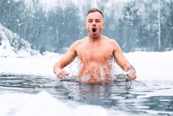 Man jumping in cold water in winter
