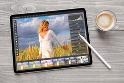 Concept of digital photo editing on tablet computer with wireless stylus pen