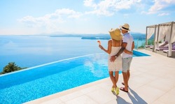 Wealthy couple enjoying beautiful sea view of luxury Mediterranean villa