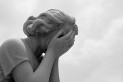 The grief of losing a loved one is captured in a marble statue of a woman crying into her hands.
