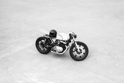 Silver rebuilt motorcycle motorbike cafe-racer is parked alone. Wild lifestyle. View from above
