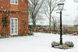 English garden of a country house in winter snow, UK