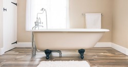 Modern bathroom interior design with clawfoot bath tub and floor tiles. Luxury, contemporary bathrooms, UK. 