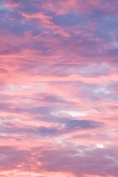 Dramatic moody sky at sunset with red, pink and blue storm clouds. Skyscape pattern, texture or background, UK