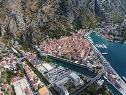 Beautiful and colorful aerial panorama of stunning Kotor Old Town and marina bay shot with drone on sunny summer day in Montenegro showing aerial view of historical architecture and tourist attraction