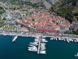 Beautiful and colorful aerial panorama of stunning Kotor Old Town and marina bay shot with drone on sunny summer day in Montenegro showing aerial view of historical architecture and tourist attraction