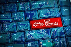 Chip Shortage or semiconductor automotive crisis concept with computer keyboard and motherboard circuits