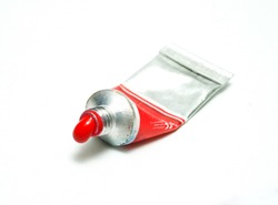 Tube of watercolor. Red watercolor. Tube of watercolor isolated on white background. red paint color flowing out of the tube, closeup isolated with shadows on a white background, copy space.