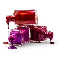 Stack of bottles with spilled nail polish over white background