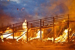 Burning wooden bridge close-up. Raging flames of fire. Firestorm closeup. Wooden structures on fire. Bright inferno flames. Hell fire. Burning constructions background. Intense combustion and heat.