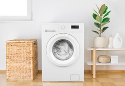 Washing machine with clothes in modern bathroom interior