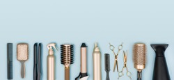 Hair stylist tools arranged in a line on blue background